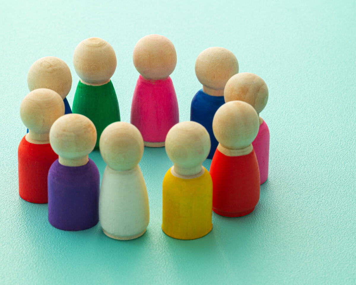 Concept of teamwork, inclusion, and teamwork, expressed with colored wooden pieces.